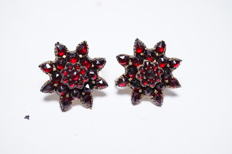 A suite of garnet and paste jewellery, comprising: a brooch, 5cm diameter; a bangle, inner circumference 16cm; two rings, sizes I and M; a pair of earrings, and a single earring, each set with rose-cut garnets; and a pai